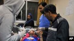 In this photo released by the Syrian official news agency SANA, a paramedic treats an injured woman wounded by Israeli missile strikes at a hospital in Damascus, Syria, Nov. 20, 2019.