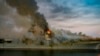 This US Navy photo released July 13, 2020, shows a fire as it continues to be fought into the evening on board the amphibious assault ship USS Bonhomme Richard at Naval Base San Diego, on July 12, 2020.