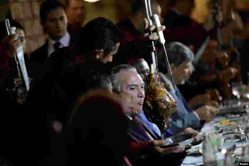 Brazil's President Michel Temer eats barbecue in a steak house after a meeting with ambassadors of meat importing countries of Brazil, in Brasilia, March 19, 2017.