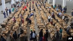 FILE - Indigenous tobacco farmers are seen at Boka Tobacco auction floors, in Harare, Zimbabwe, Tuesday May 14, 2013.