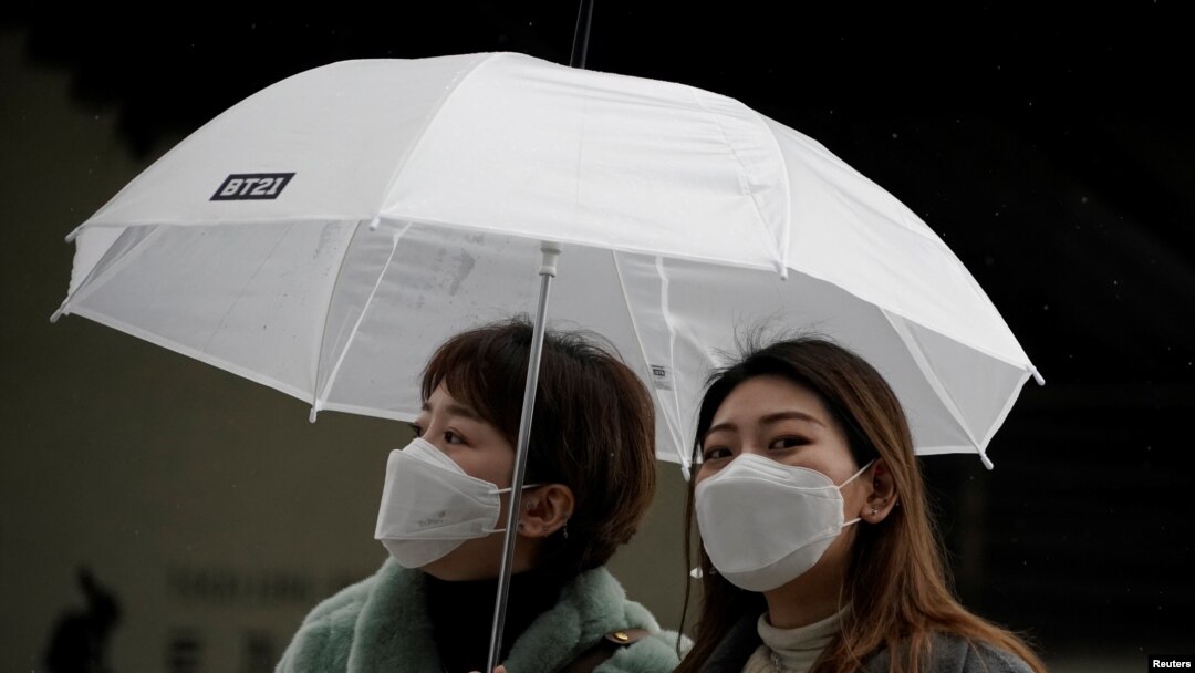 Passengers wearing masks to prevent contacting the coronavirus walk outside Seoul Railway Station in Seoul, South Korea, February 25, 2020. REUTERS/Kim Hong-Ji