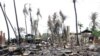 People shift through damaged buildings in Sittwe, capital of Rakhine state, western Burma, June 16, 2012.