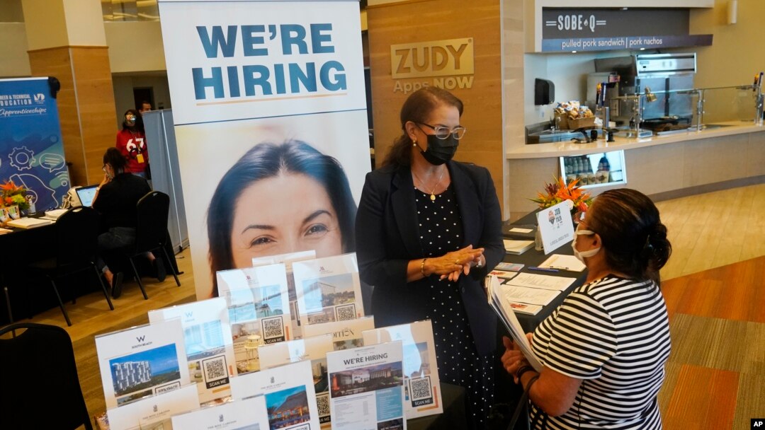 FILE - Marriott human resources recruiter Mariela Cuevas, left, talks to Lisbet Oliveros, during a job fair at Hard Rock Stadium, in Miami Gardens, Florida, Sept. 3, 2021.