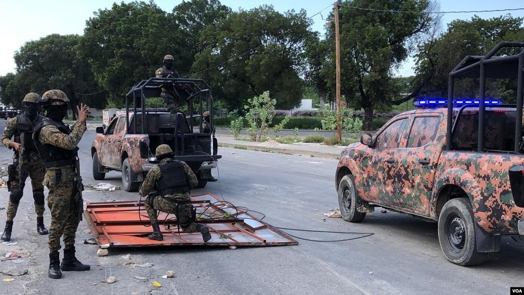 Haiti's National Police guard remove makeshift barricades made of steel fences and tree branches protesters placed to block the National Palace entrance, Oct. 31, 2019. (Photo: Matiado Vilme / VOA) 