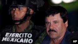 FILE - Mexican drug lord Joaquin "El Chapo" Guzman, right, is escorted by soldiers and marines to a waiting helicopter, at a federal hangar in Mexico City, Jan. 8, 2016. 